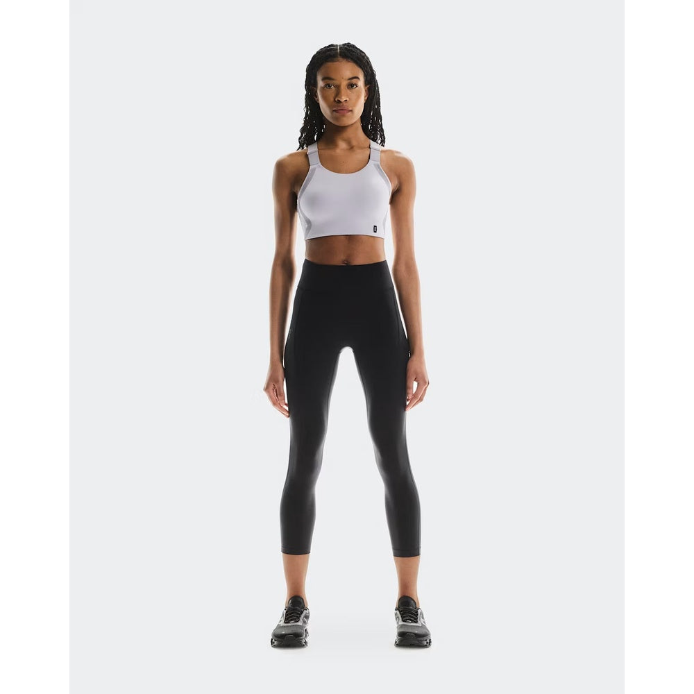 Woman wearing On Running Performance Tights 7/8 in black with white sports bra