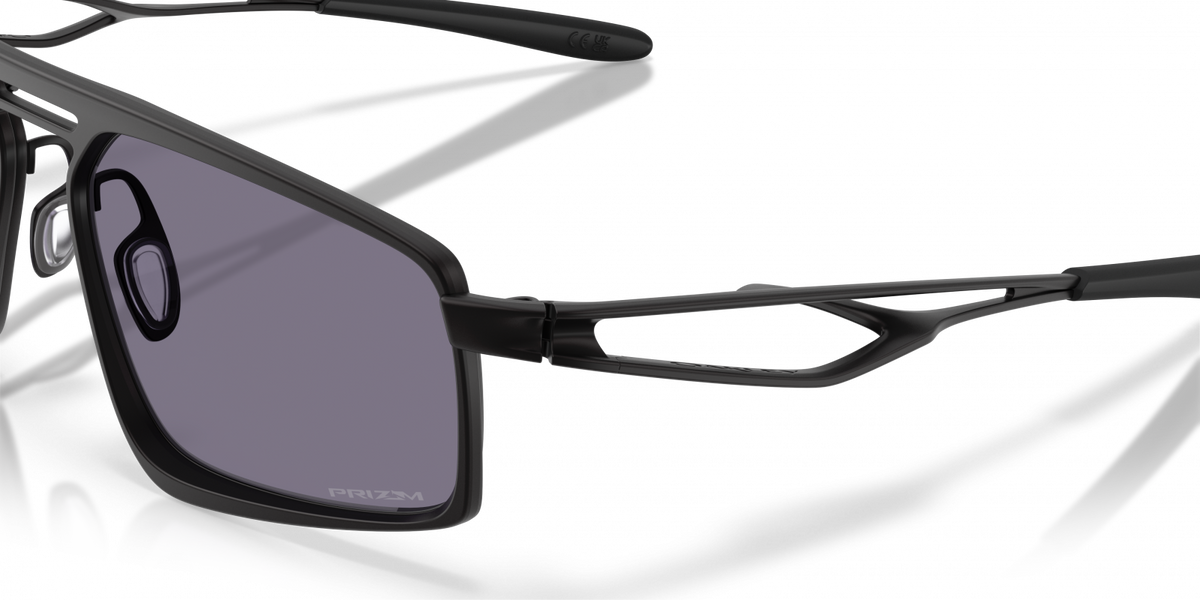 Close-up detail of Oakley Bushwick temple hinge and lens in satin black with grey Prizm lens
