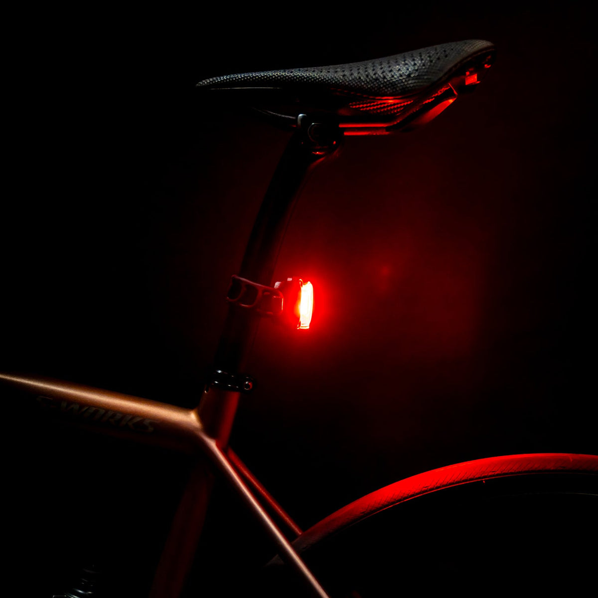 Lezyne Zecto Drive Max 400 rear bike light glowing red in darkness on seatpost