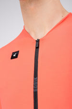 Close-up detail of Gobik Avalon Jersey zipper and brand logo badge in Lava color