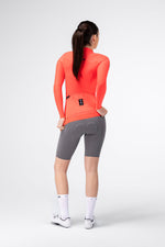 Gobik Avalon Long Sleeve Jersey in Lava color, female model rear view showing back pockets and fit