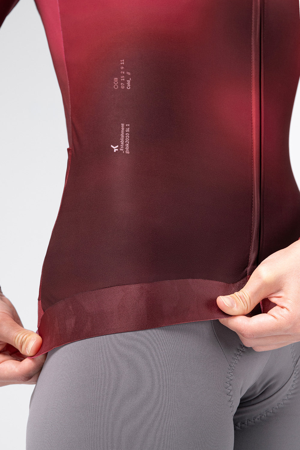 Close-up detail of Gobik Vanquish jersey hem and silicone gripper in Monarch burgundy colorway