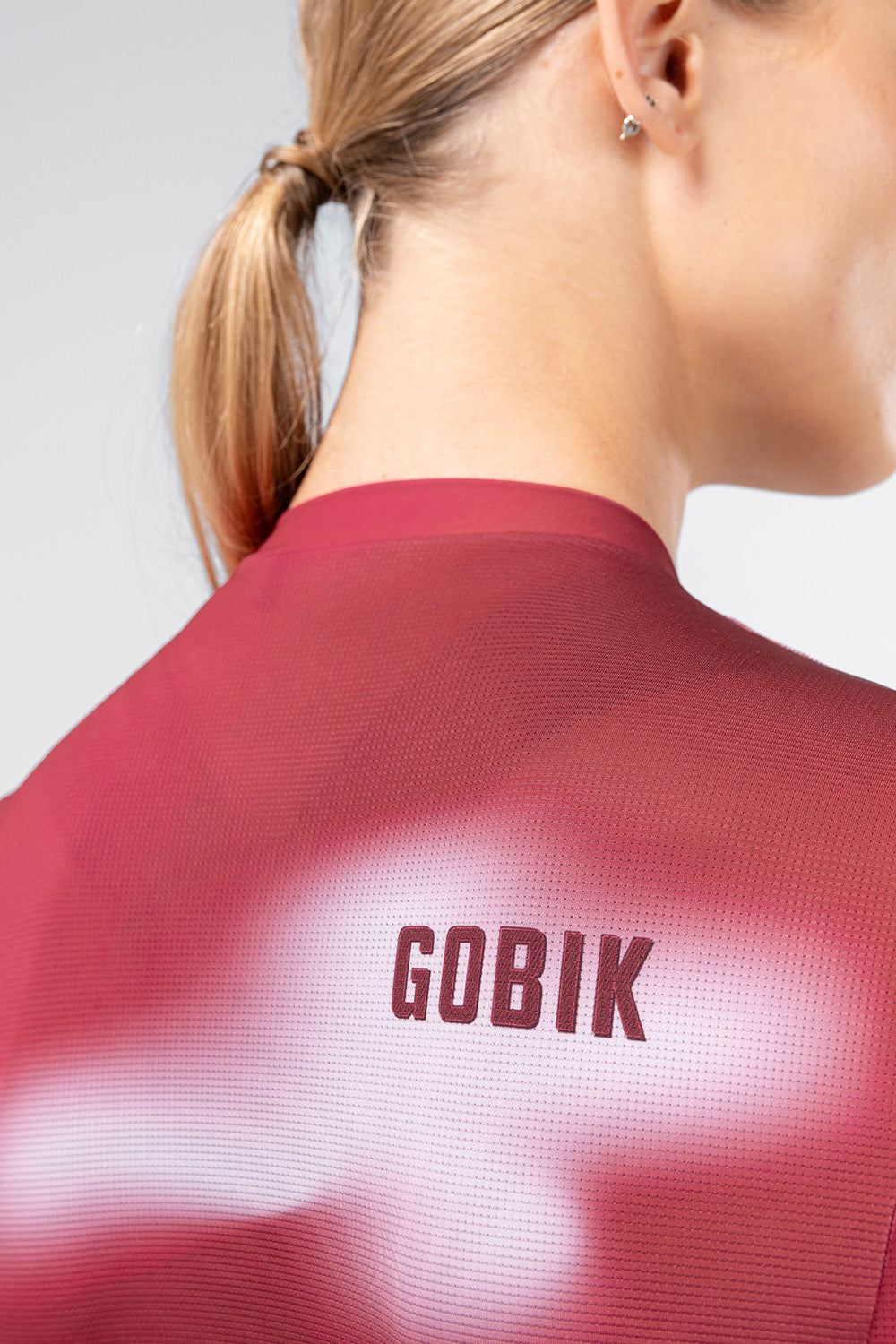 Close-up back collar detail of Gobik Vanquish jersey in Monarch colorway on female model