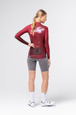Female model rear view of Gobik Vanquish long sleeve jersey in Monarch red, showing back pocket area