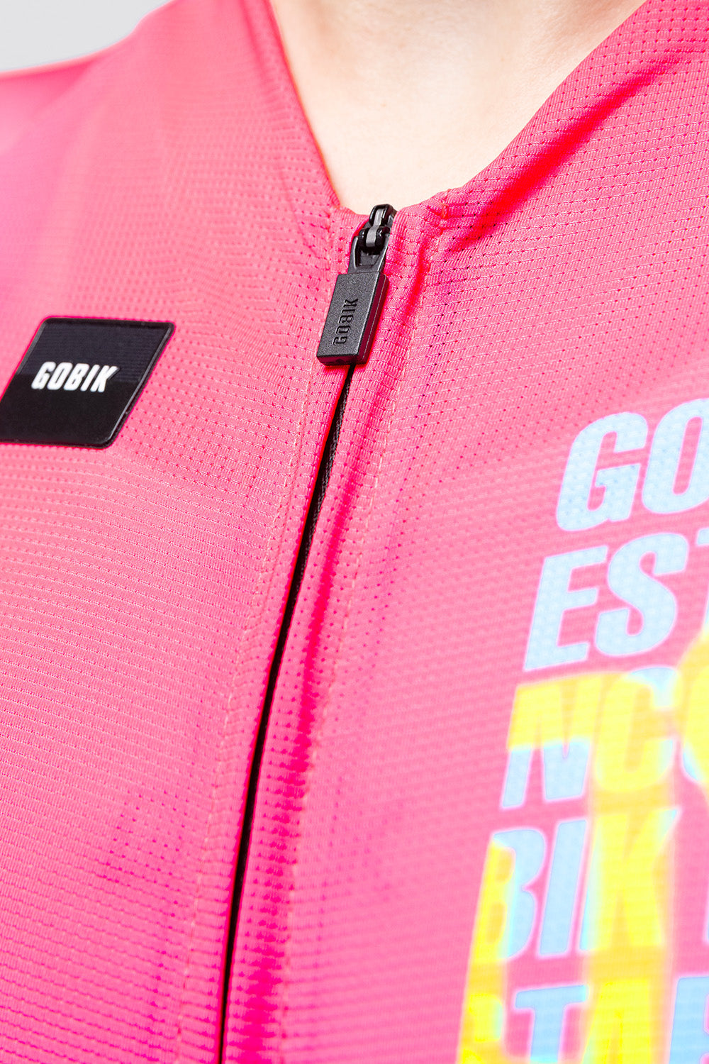 Gobik CX Pro cycling jersey in neon pink Drip colorway showing zipper and brand label detail