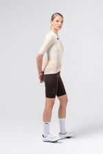Female model wearing Gobik CX Pro 4.0 short sleeve jersey in almond with dark brown bib shorts