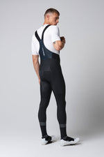 Man wearing black Gobik cycling bib shorts with suspenders, rear view