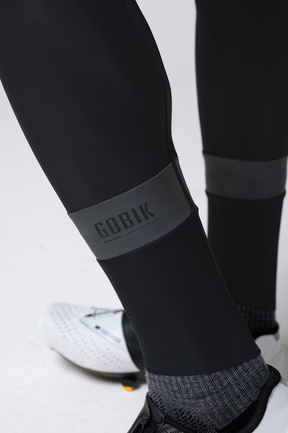 Close-up of Gobik black cycling bib shorts showing brand logo and fabric details