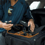 Person packing Thule Roundtrip bike duffel bag showing black exterior and orange interior