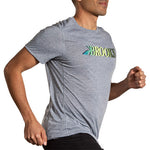 Man running wearing Brooks Distance Short Sleeve 3.0 in heather ash gray with gradient logo