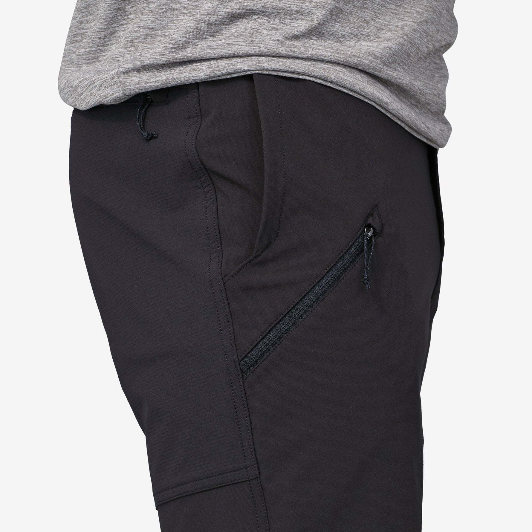 Close-up of black Patagonia trail pants showing zippered side pocket and drawstring waist