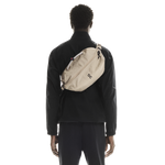 On Sling Pack 9L in Biscuit worn crossbody on model's back, studio shot