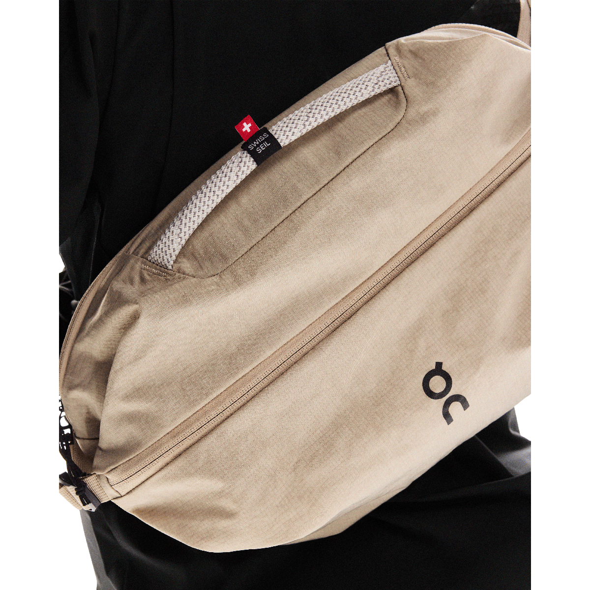 On Sling Pack 9L in biscuit beige worn as crossbody bag with Swiss Seil rope handle