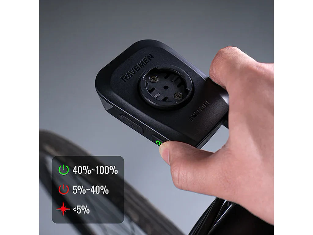 Hand holding Ravemen FR1100 bike light showing power button and battery level indicator legend