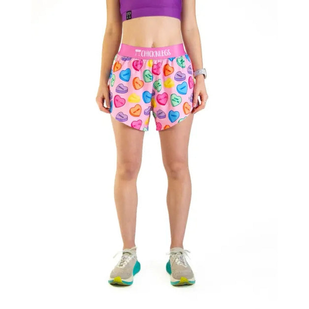 Woman wearing ChicknLegs candy hearts print athletic shorts with pink waistband