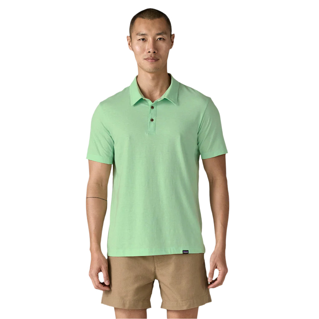 Man wearing light green Patagonia polo shirt with khaki shorts on white background