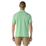 Back view of man wearing light green Patagonia Essential polo shirt with khaki shorts