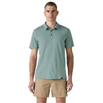 Man wearing sage green Patagonia polo shirt with khaki shorts on white background