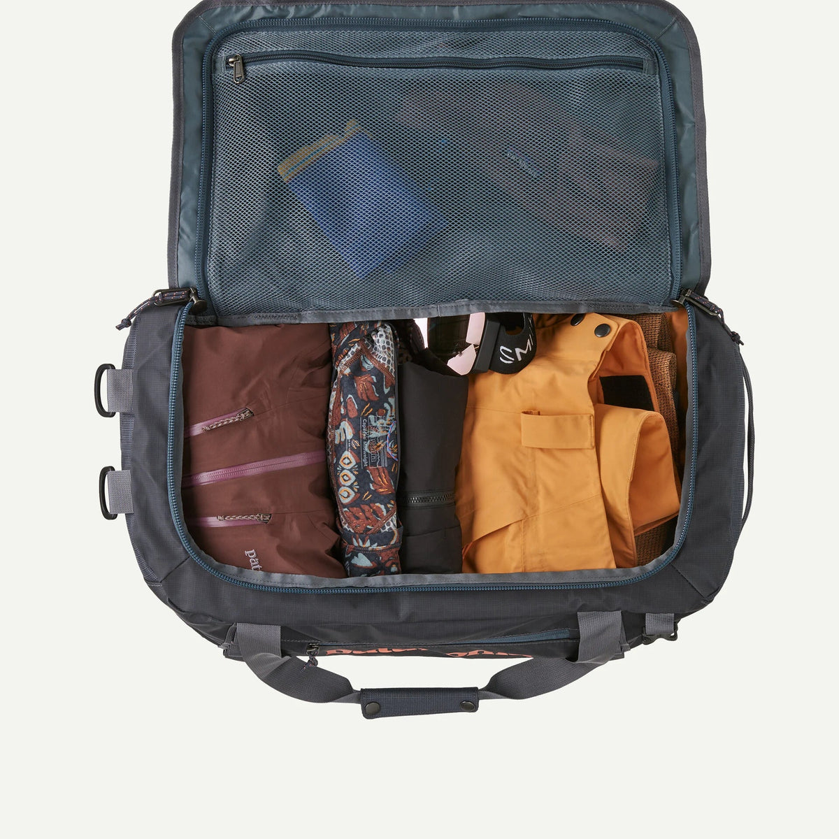 Interior view of open Patagonia Black Hole 40L duffel bag packed with clothing and gear, showing mesh lid pocket