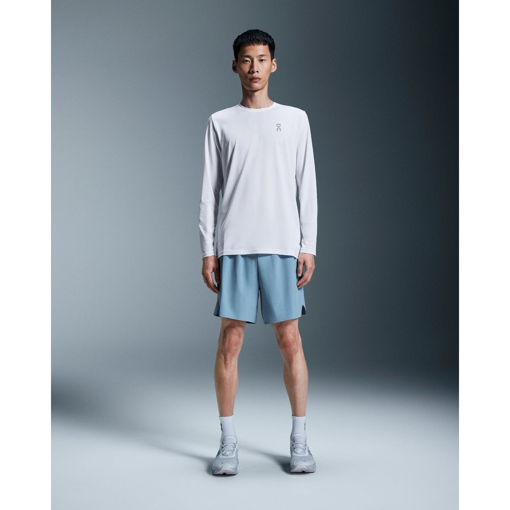 Man wearing white On Core Long-T shirt with light blue shorts