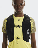 On Ultra Vest Pro Unisex in black worn over yellow On running shirt, front view