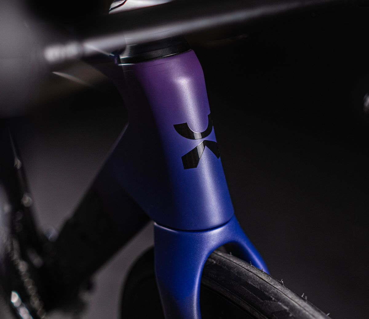 Close-up of X-LAB AD9 head tube showing purple-blue gradient finish and brand logo