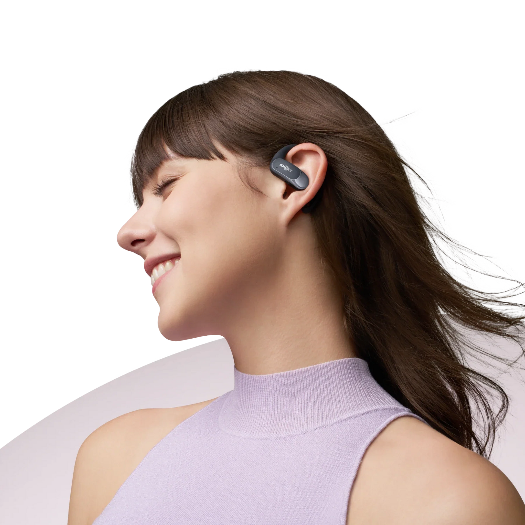 Woman wearing black Shokz OpenFit Air earbuds in profile, smiling