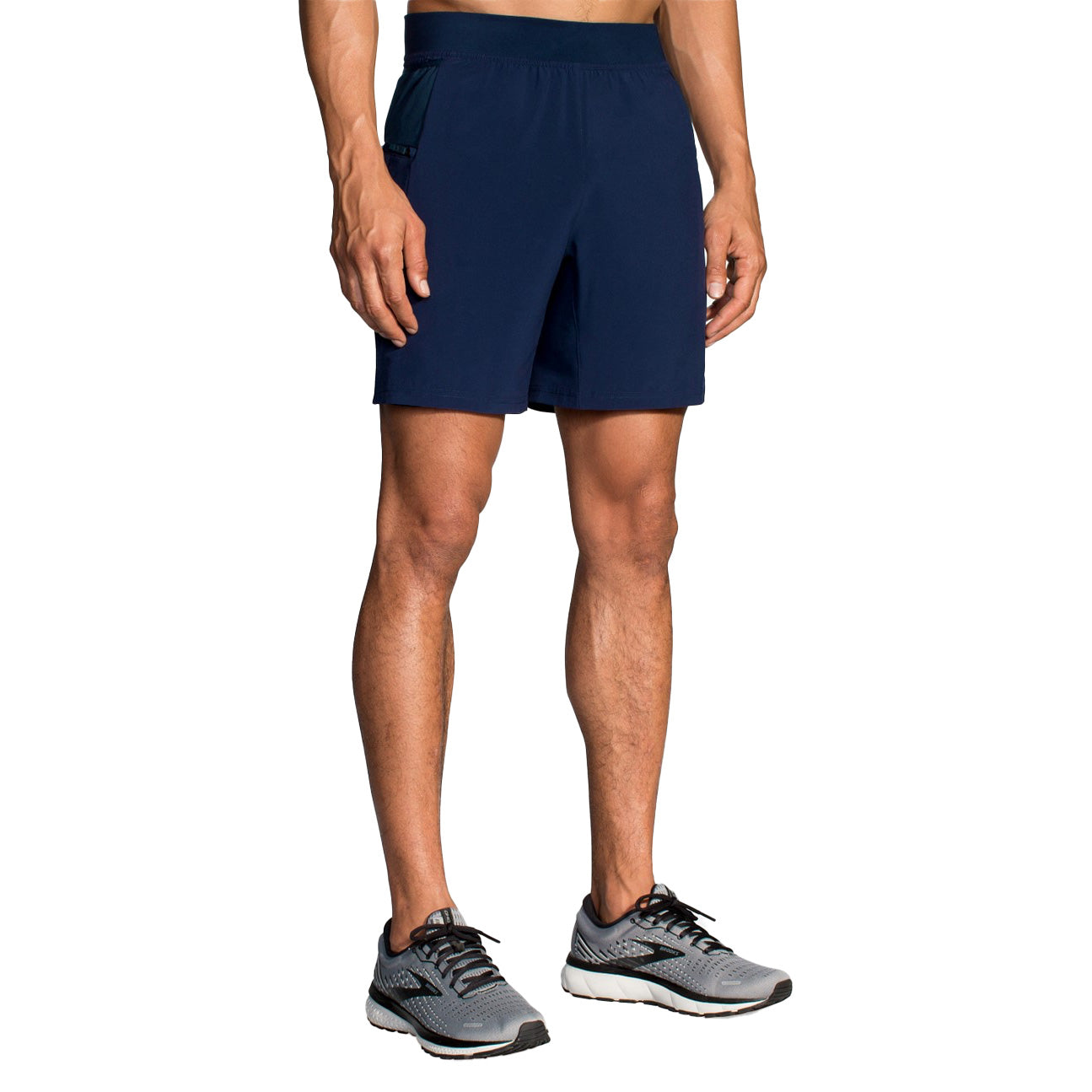 Man wearing navy Brooks Sherpa 7-inch running shorts with gray athletic shoes