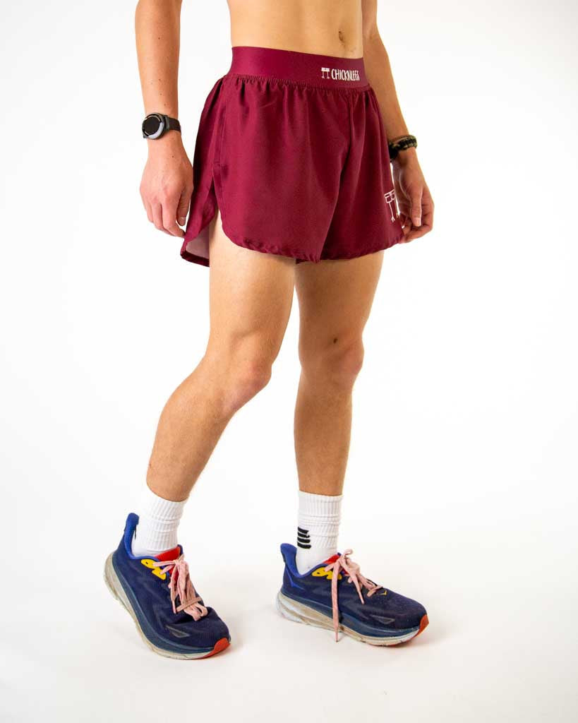 Woman wearing maroon ChicknLegs athletic shorts with split sides and running shoes