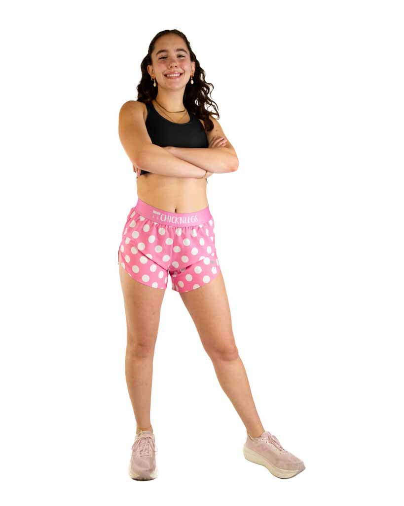 Woman wearing ChicknLegs pink polka dot athletic shorts with black sports bra