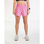 Woman wearing pink polka dot athletic shorts with ChicknLegs branding on waistband