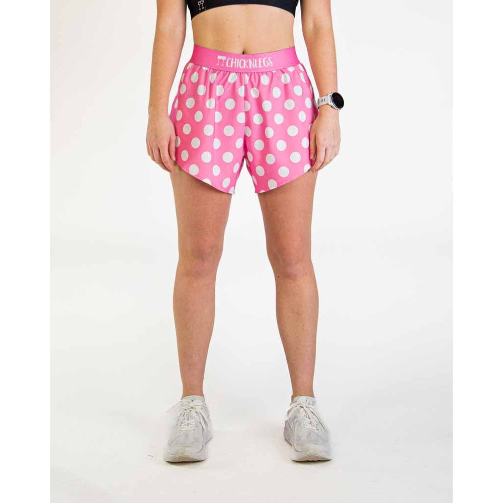 Woman wearing pink polka dot athletic shorts with ChicknLegs branding on waistband