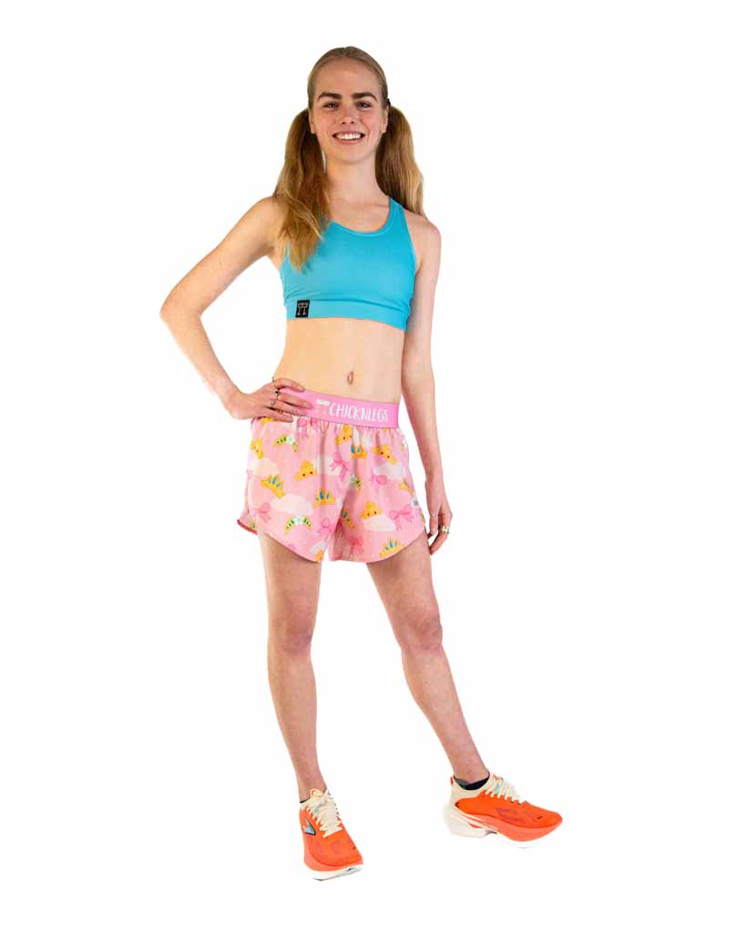 Woman wearing pink split shorts with yellow duck pattern and blue sports bra
