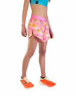 Woman wearing pink ChicknLegs split shorts with princess tiara pattern and running shoes