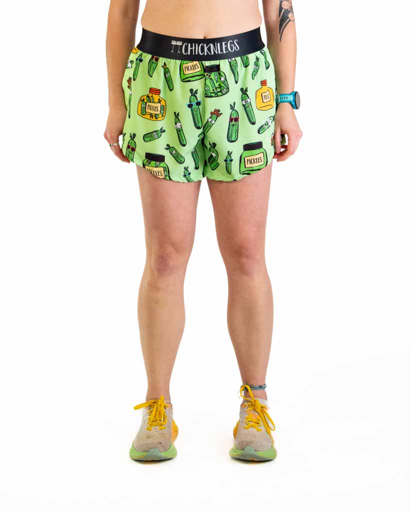 Woman wearing ChicknLegs green pickle print running shorts with black waistband
