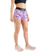 Woman wearing purple athletic shorts with pink pig pattern and black waistband