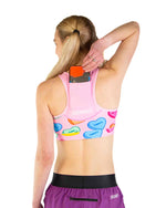 ChicknLegs pink sports bra with candy hearts pattern, back view with phone storage