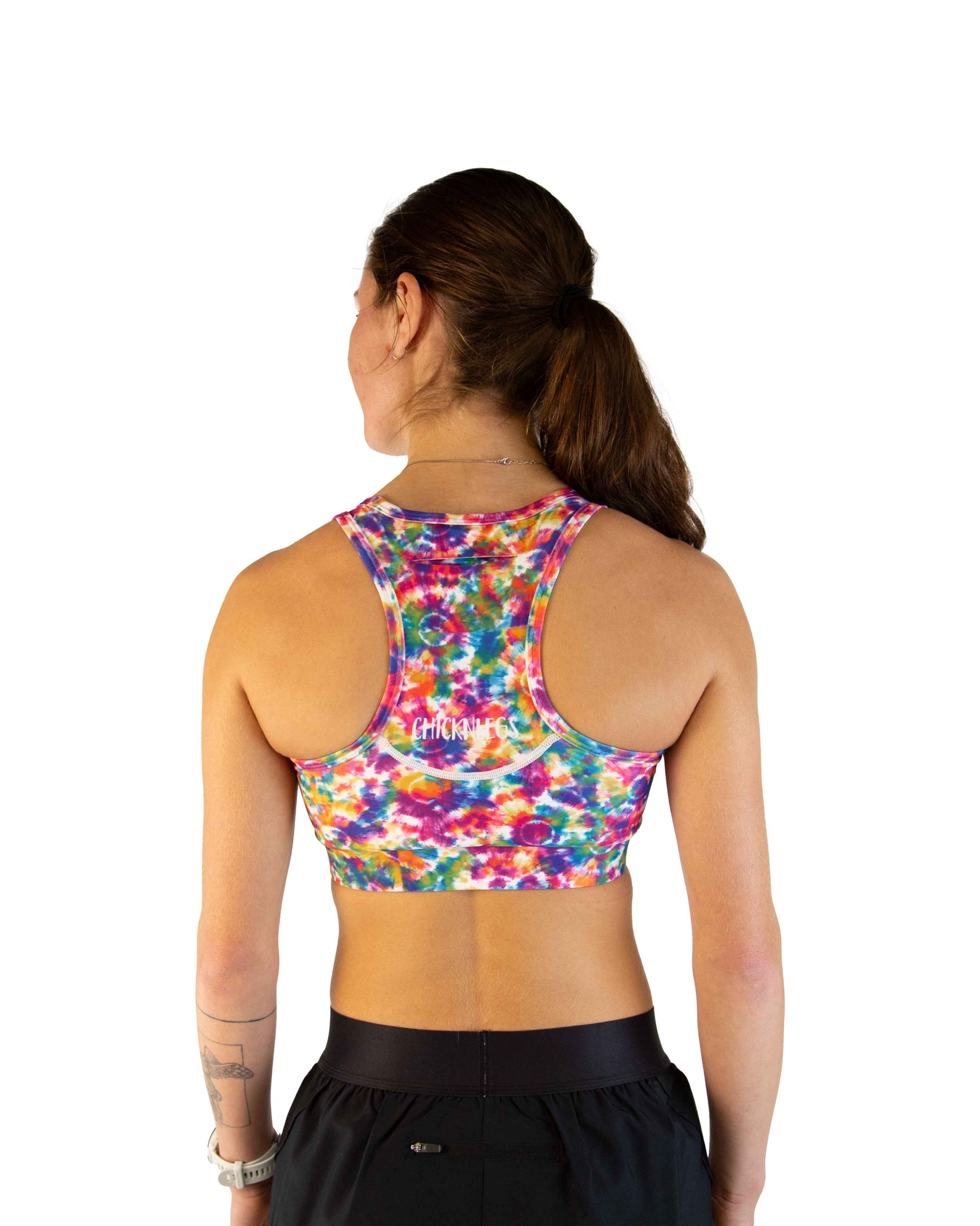 ChicknLegs tie-dye sports bra in rainbow colors shown from back on model