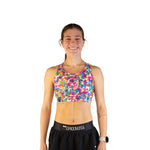 Woman wearing ChicknLegs tie-dye sports bra in vibrant multicolor pattern