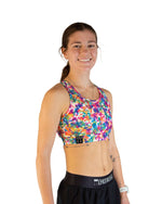 Woman wearing ChicknLegs tie-dye sports bra in vibrant multicolor pattern