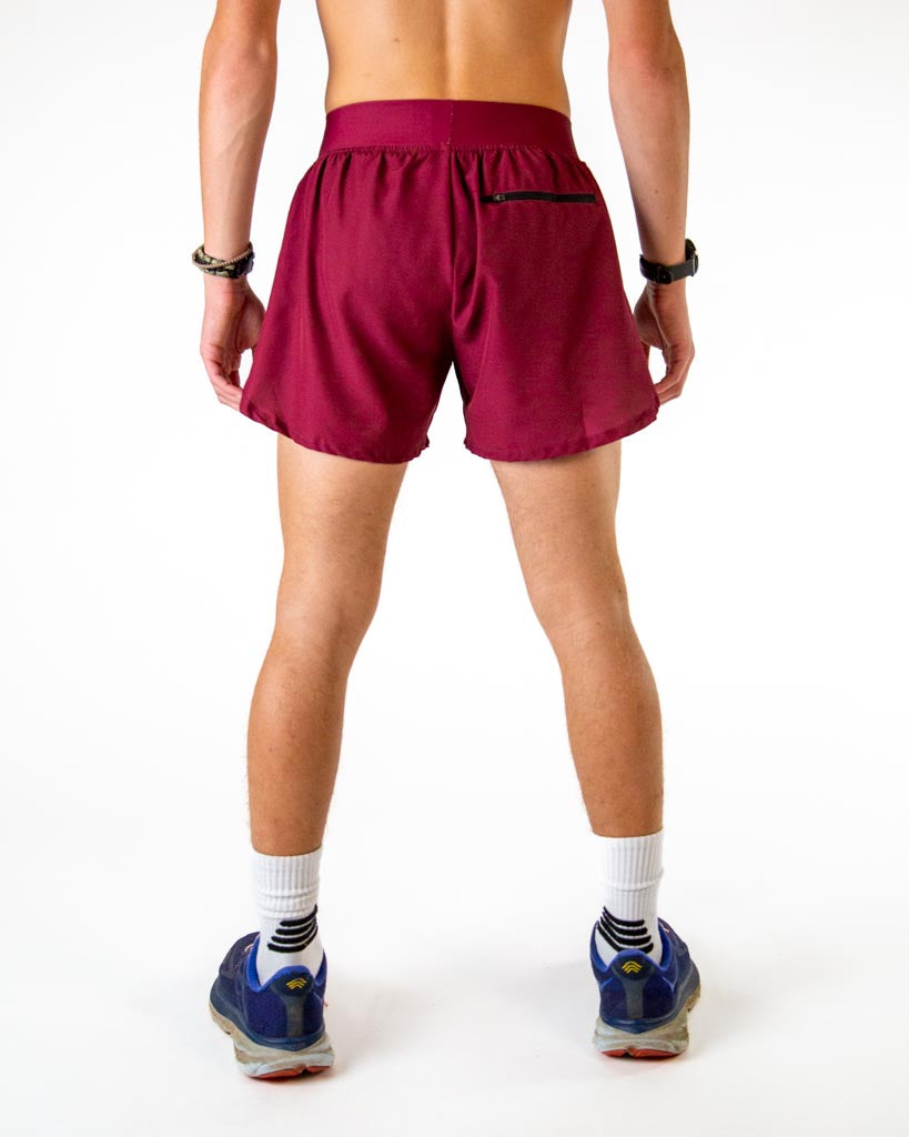 Back view of man wearing maroon athletic shorts with split design
