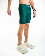 Man wearing forest green ChicknLegs 8-inch compression shorts with running shoes