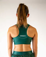 Back view of woman wearing ChicknLegs forest green racerback sports bra