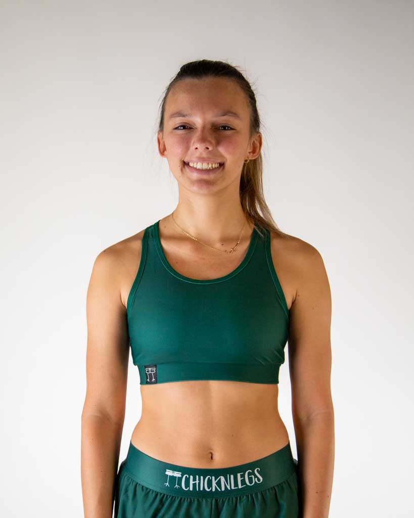 Woman wearing ChicknLegs forest green sports bra and matching athletic shorts