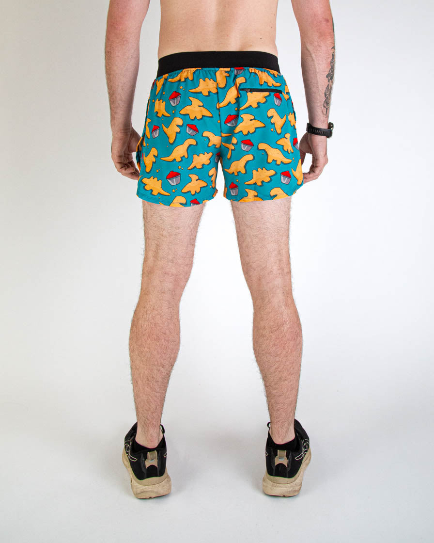 Back view of man wearing teal blue shorts with orange chicken nugget dinosaur pattern