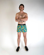 Man wearing ChicknLegs blue shorts with orange nugget pattern in studio photo