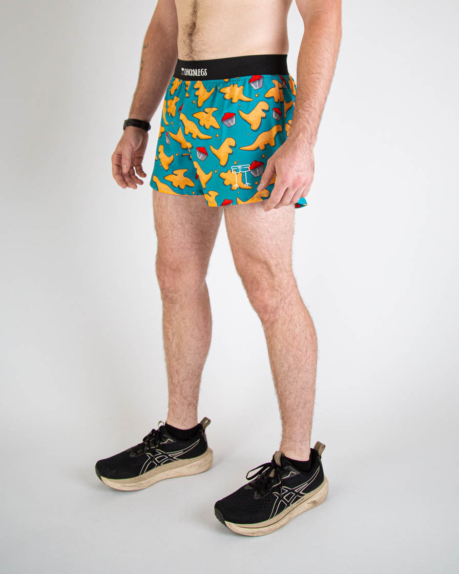 Man wearing ChicknLegs turquoise shorts with orange chicken nugget pattern and running shoes