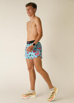 Man wearing light blue running shorts with pink flamingo pattern and black waistband