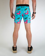 Men's turquoise compression shorts with pink flamingo and tropical leaf pattern, back view