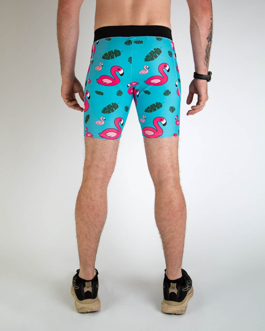 Men's turquoise compression shorts with pink flamingo and tropical leaf pattern, back view
